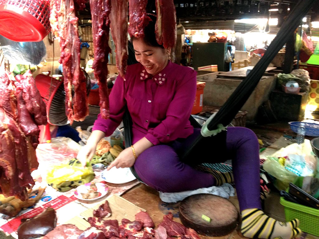 Šťastná paní na tržnici ve městě Kampot, Kambodža